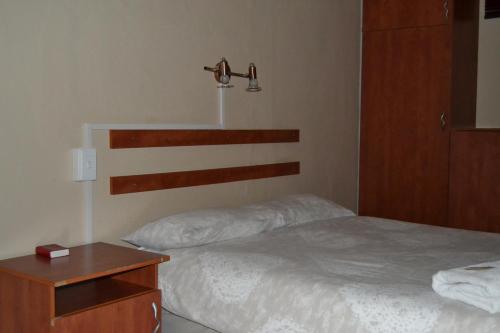 a bedroom with a bed and a wooden headboard at Kenhardt Hotel in Kenhardt