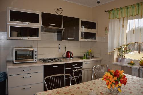 una cocina con una mesa con un jarrón de flores en Pokoje Adriano en Grudziądz
