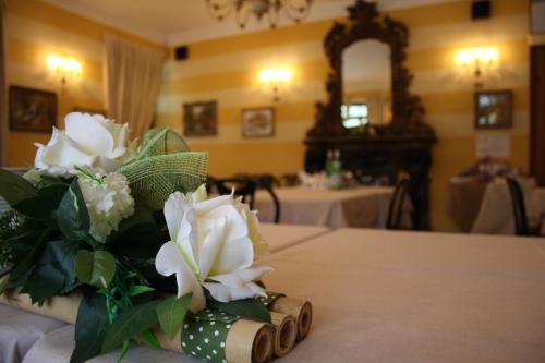 un vase rempli de fleurs blanches sur une table dans l'établissement Hotel La Torre, à Castiglione dʼIntelvi