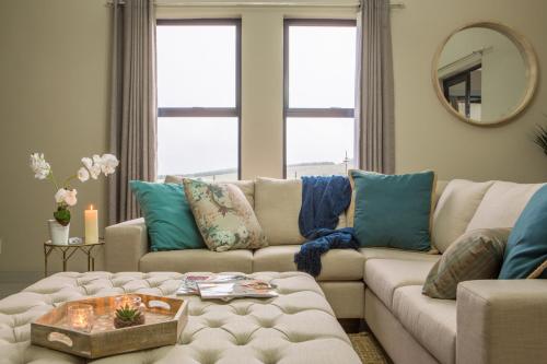 a living room with a white couch and blue pillows at The Living Collective - The Gates in Hilton