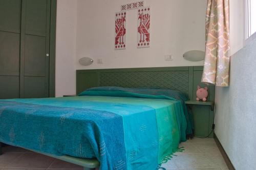 a bedroom with a green bed with blue sheets at Sardegna Isola Rossa La Terrazza panoramiccissimo Cod iun S 8250 in Trinità dʼAgultu