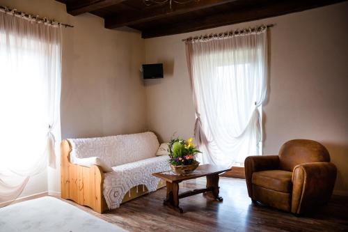 a living room with a couch and a chair and a table at Ca' Baetti l'Antica Corte in Roncola