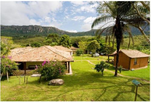 a house with a palm tree and a house with a yard at Calcada Sao Jose in Tiradentes