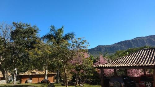 a house with a gazebo and trees and mountains at Calcada Sao Jose in Tiradentes