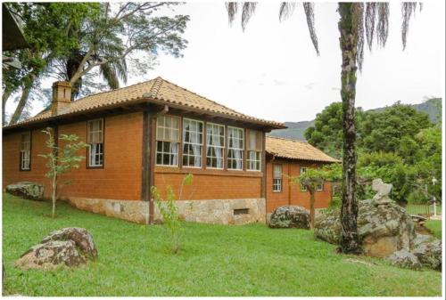 a house with a large window in a yard at Calcada Sao Jose in Tiradentes