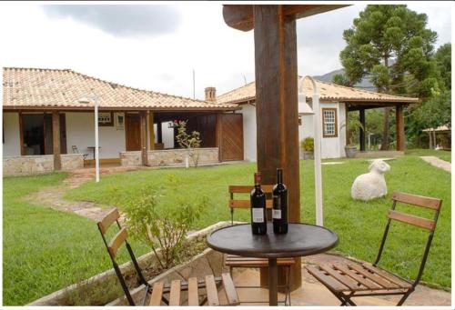 a table with bottles of wine and two chairs at Calcada Sao Jose in Tiradentes