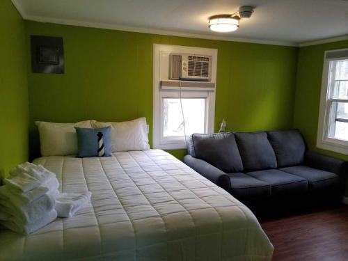 a bedroom with a large bed and a couch at Lighthouse Cabins in Old Orchard Beach