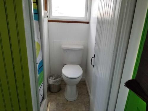 a small bathroom with a toilet and a window at Lighthouse Cabins in Old Orchard Beach