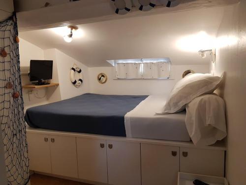 une chambre avec un grand lit avec des draps et des oreillers bleus dans l'établissement Suquet26, à Cannes