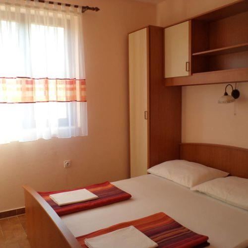 a small room with a bed and a window at villa Adriana apartments in Rab