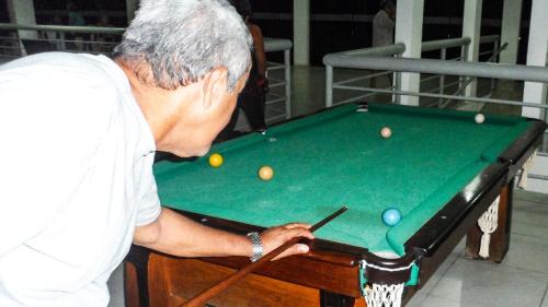 a man playing pool on a pool table at Thermas Hotel in Salgadinho