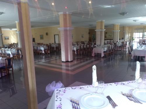 a dining room with white tables and chairs at Hotel Grandinetti in Parenti
