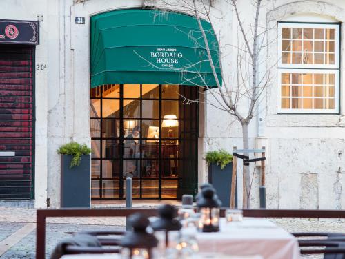a restaurant with a green awning in front of a building at Dear Lisbon - Bordalo Palace Chiado in Lisbon