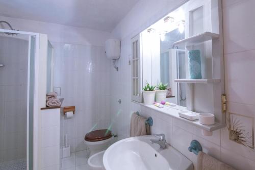 Baño blanco con lavabo y aseo en Appartamento a 10 minuti a piedi dal mare, en Santa Maria Navarrese
