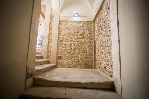 a staircase in a building with a stone wall at Ortigia Casa Fab in Siracusa