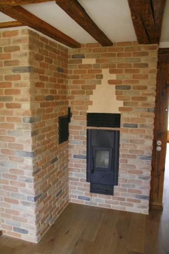a brick wall with a fireplace in a room at Waldvogel Ferienzimmer klimatisiert in Immenstaad am Bodensee