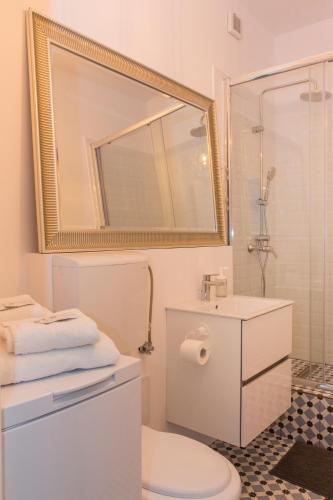 a bathroom with a toilet and a sink and a mirror at Premium Studio by MRG Apartments in Bucharest