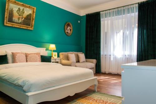 Premium Studio by MRG Apartments في بوخارست: غرفة نوم بسرير ابيض وجدار اخضر