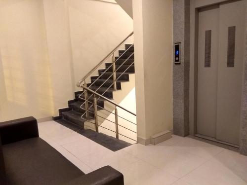 a staircase in a building with a black couch at JK Rooms 126 Parashar Legacy - Opp Railway Station in Nagpur
