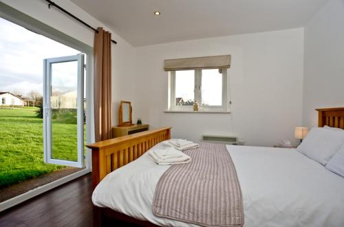 a bedroom with a bed and a large window at Stoneleigh Village in Sidmouth