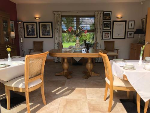 a dining room with a wooden table and chairs at Crowfield Country House in Aghadowey