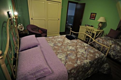 a bedroom with two beds and a chair and a table at Il Giardino Dei Limoni in Montecassiano