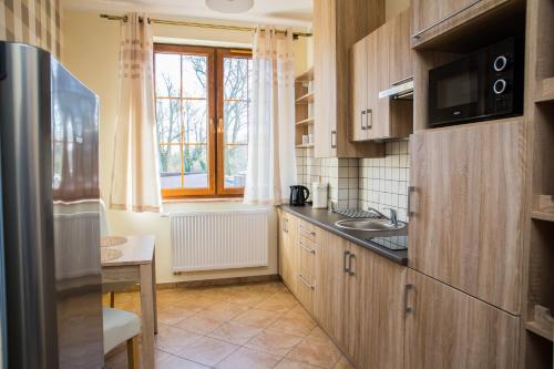 una piccola cucina con lavandino e finestra di Apartament Żaglowy 2 a Puck