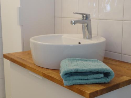 a bathroom sink with two towels on a wooden shelf at Villa gruddbo in Sollerön