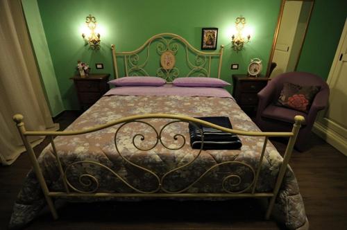 a green bedroom with a bed and a chair at Il Giardino Dei Limoni in Montecassiano