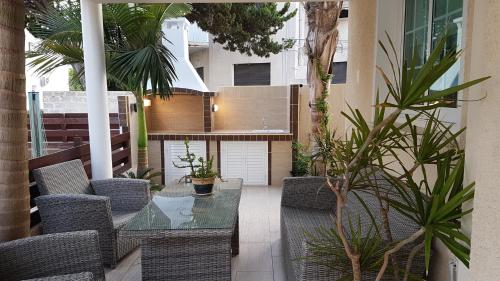 a patio with a table and chairs and plants at Philippou Beach Villas & Apartments in Larnaca