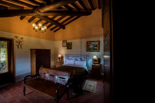 a bedroom with a bed and a bench in it at Castello di Valenzano in Arezzo