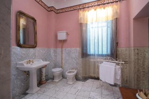 La salle de bains est pourvue d'un lavabo, de toilettes et d'un miroir. dans l'établissement Castello di Valenzano, à Arezzo