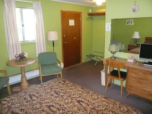 a hotel room with a bed and a desk and a computer at The Village Motel in Richfield Springs