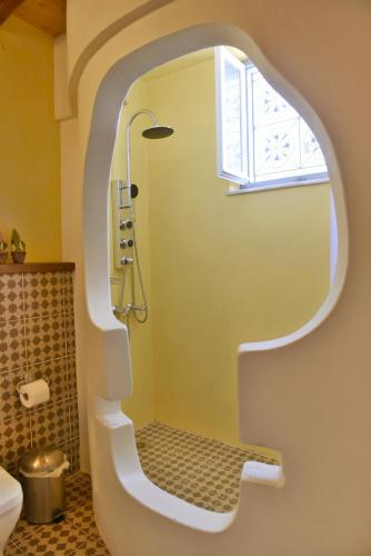 a bathroom with a shower with a window at Manolia in Hydra