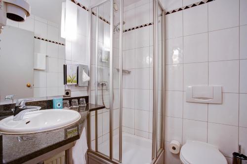 a bathroom with a sink, toilet and bathtub at Centro Hotel Nürnberg in Nuremberg