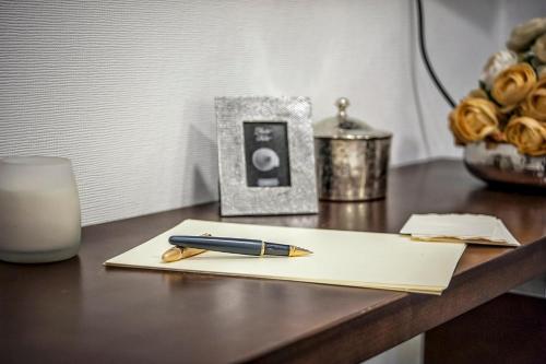 a pen on a paper on a table with a candle at Hotel Santa Chiara in Nocera Inferiore