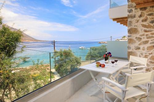 a balcony with a table and chairs and a view of the ocean at Molos Apartments in Loutro