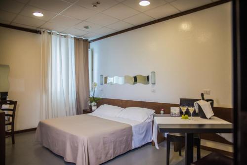 una camera d'albergo con letto e tavolo di Hotel Santa Chiara a Nocera Inferiore