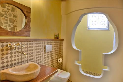 a bathroom with a wooden tub sink and a window at Manolia in Hydra