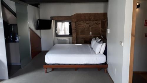 a bedroom with a bed and a dresser at Blanco Apartamentos Turísticos in Santiago de Compostela