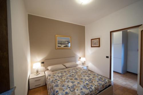 a bedroom with a bed and two lamps and a mirror at Casa vacanze da Carla in Abbadia Lariana