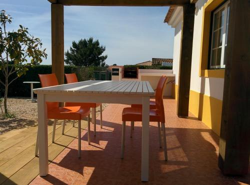 a white table and chairs on a patio at Casas das Amoreiras in Aldeia do Meco