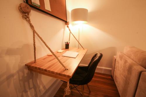 a desk with a lamp and a chair next to a couch at City Centre Apartment 1 in Shkodër