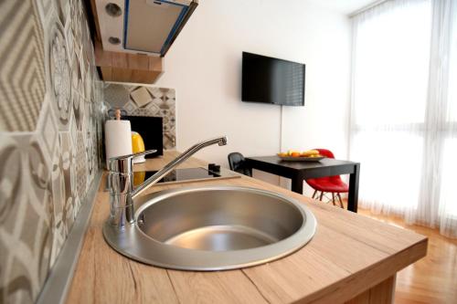 zlew ze stali nierdzewnej w kuchni z biurkiem w obiekcie Apartment Noah w mieście Zadar