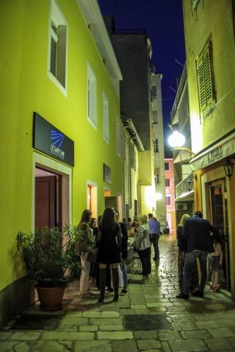 a group of people walking down a street at night at Downtown Boutique Hostel in Zadar