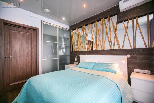トゥルゴヤクにあるTurgold Apartmentsのベッドルーム1室(ベッド1台、木製のヘッドボード付)