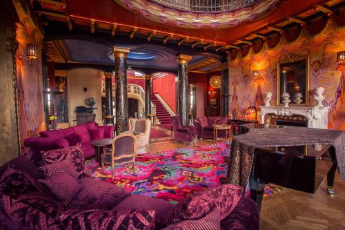 a living room with a purple couch and a fireplace at Chateau de Bézyl in Sixt-sur-Aff