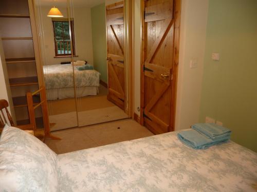 a bedroom with a bed and a mirror and a door at Crotlieve Barn in Rostrevor