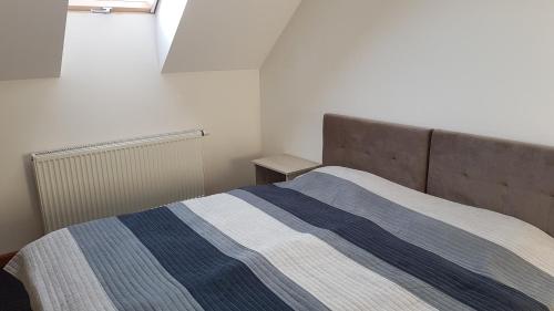 um quarto com uma cama com um cobertor azul e branco em Apartament z tarasem Zełwągi 15 em Mikolajki