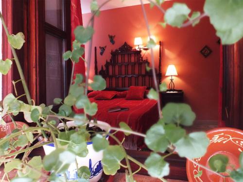 a bedroom with a bed with a red bedspread at Hotel Rural Posada Los Caballeros in Almagro